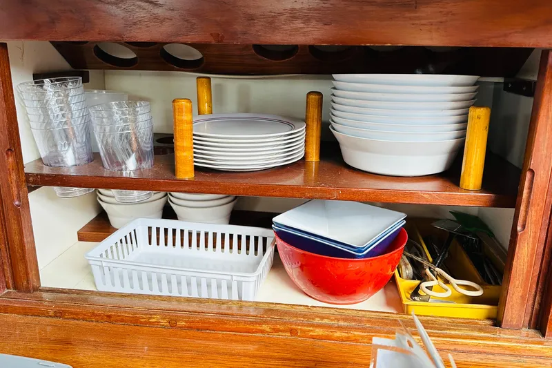 Slide: The Image of Galley storage on 1981 Cape George 36 Cutter with dishes and utensils neatly organized. - 21