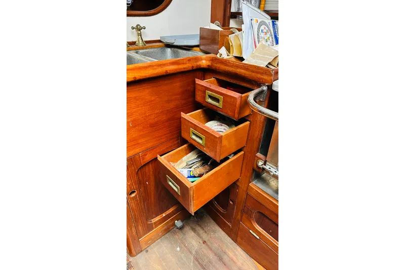 Slide: The Image of Wooden drawers in a 1981 Cape George 36 Cutter sailboat kitchen area. - 23
