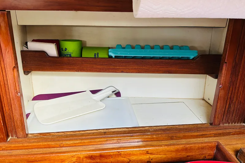 Slide: The Image of Interior shelf of 1981 Cape George 36 Cutter with kitchen items and wooden finish. - 24