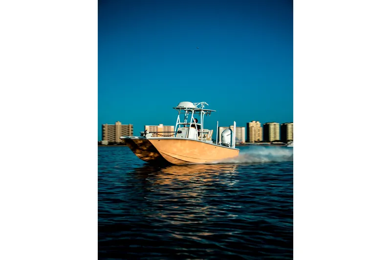 Slide: The Image of 2026 Broadwater Boatworks 25 Bay Cat cruising on water with city skyline backdrop. - 24