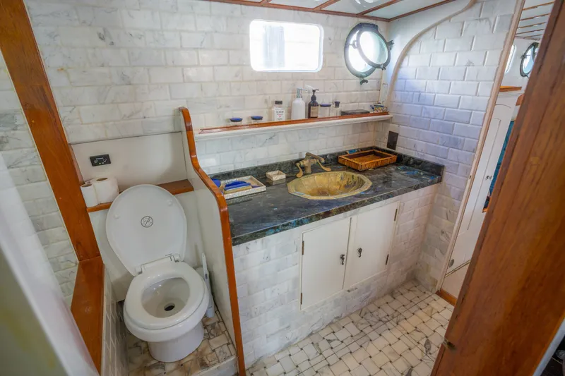 Slide: The Image of Vintage 1922 Blanchard Shipyard bathroom with marble tiles and brass fixtures. - 55