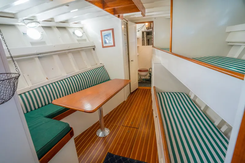 Slide: The Image of Interior of 1922 Blanchard Shipyard Custom boat with striped seating and wooden table. - 46