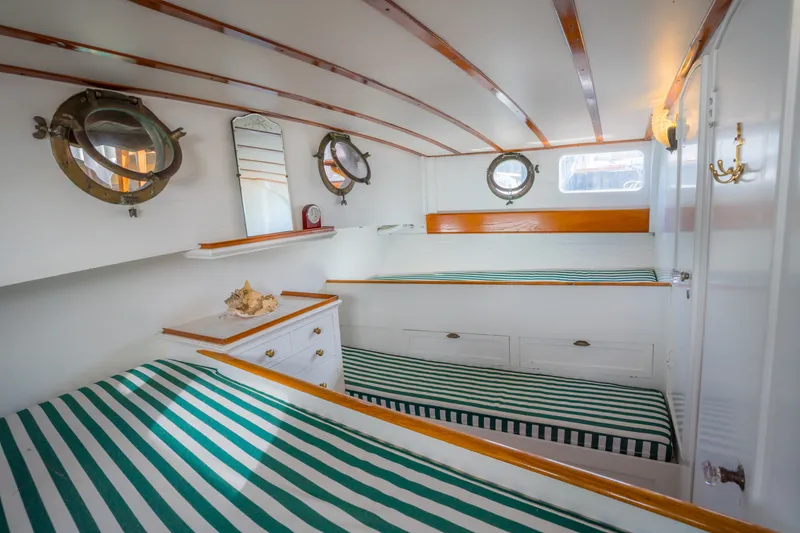 Slide: The Image of 1922 Blanchard Shipyard Custom boat interior with striped bedding and vintage portholes. - 65