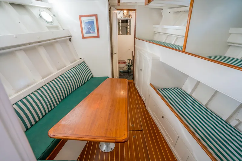 Slide: The Image of Interior of 1922 Blanchard Shipyard Custom boat with striped seating and wooden table. - 48