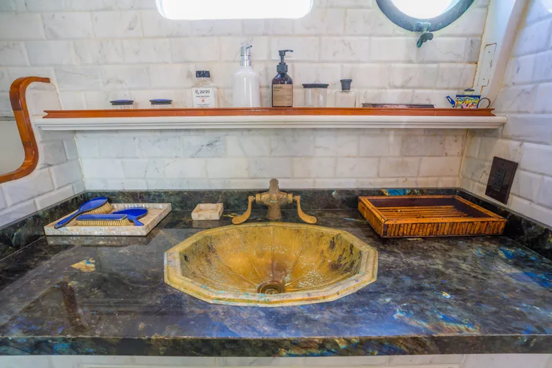 Slide: The Image of Vintage ship bathroom with marble sink, brass faucet, and toiletries on a 1922 Blanchard Shipyard vessel. - 58