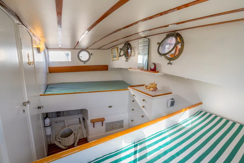 Slide: The Image of Interior of 1922 Blanchard Shipyard Custom boat with striped bedding and portholes. - 67