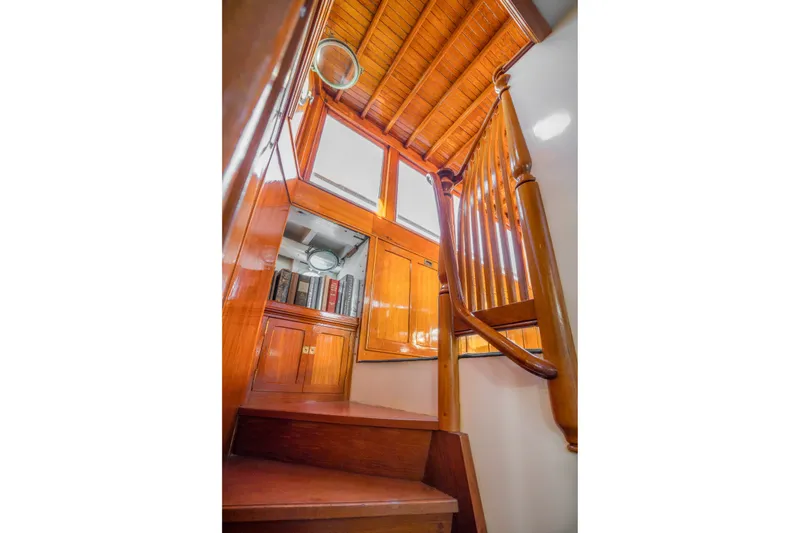 Slide: The Image of Wooden staircase inside 1922 Blanchard Shipyard custom boat, featuring polished wood and bookshelves. - 41