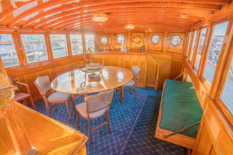 Slide: The Image of Luxurious 1922 Blanchard Shipyard custom yacht interior with wooden dining area and porthole windows. - 38