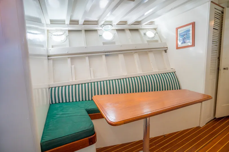 Slide: The Image of Cozy 1922 Blanchard Shipyard Custom boat interior with striped seating and wooden table. - 49