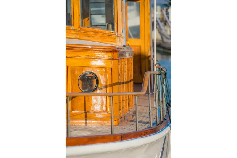 Slide: The Image of Wooden deck and cabin of a 1922 Blanchard Shipyard custom boat, featuring a porthole. - 102