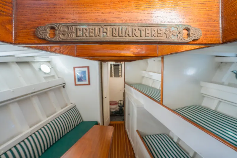 Slide: The Image of 1922 Blanchard Shipyard Custom boat crew quarters with wooden decor and striped seating. - 63