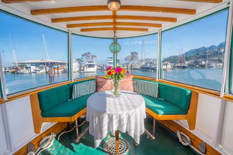 Slide: The Image of Cozy 1922 Blanchard Shipyard custom boat interior with vibrant seating and waterfront view. - 30