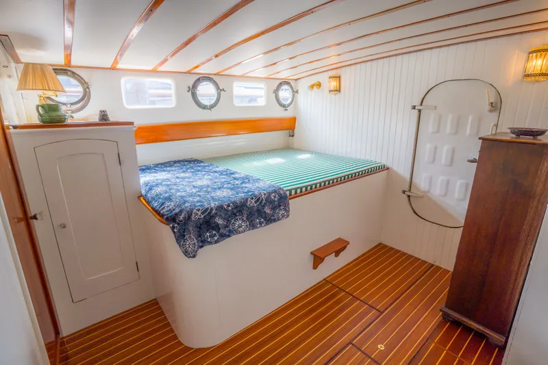 Slide: The Image of 1922 Blanchard Shipyard Custom boat interior with cozy bed, wooden accents, and nautical decor. - 54