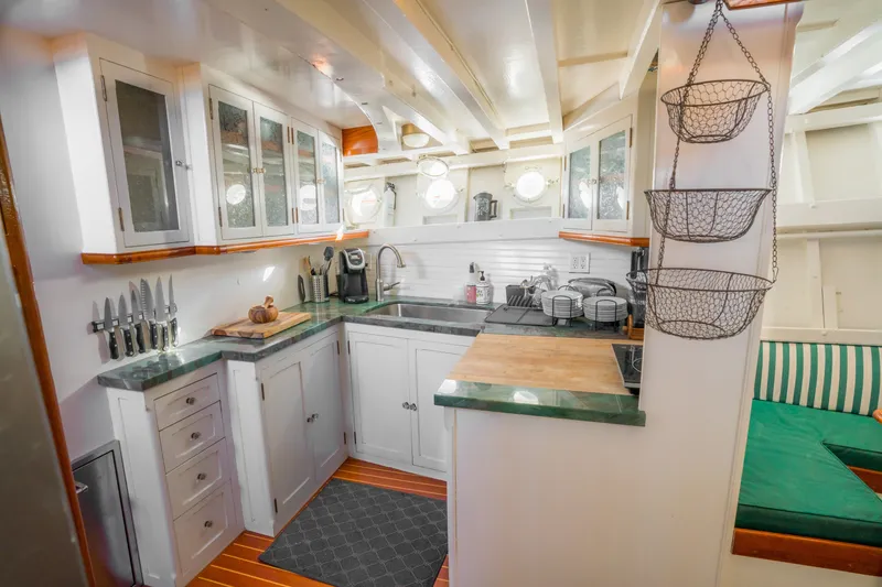 Slide: The Image of 1922 Blanchard Shipyard Custom boat kitchen with white cabinets and green countertops. - 44