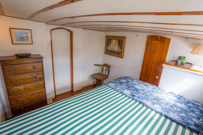Slide: The Image of Cozy 1922 Blanchard Shipyard custom boat cabin with striped bedding and wooden furniture. - 51