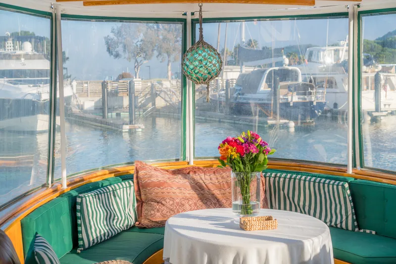 Slide: The Image of Cozy 1922 Blanchard Shipyard boat interior with floral centerpiece and marina view. - 31