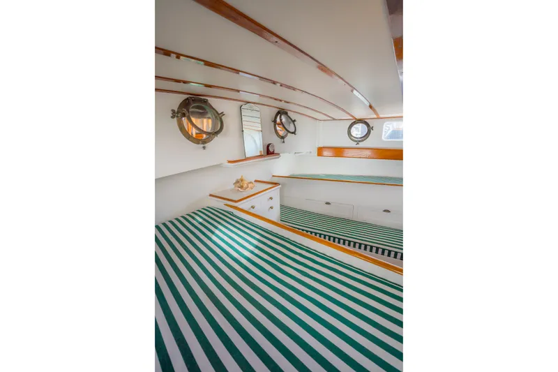 Slide: The Image of Interior of 1922 Blanchard Shipyard custom boat with striped bedding and portholes. - 64