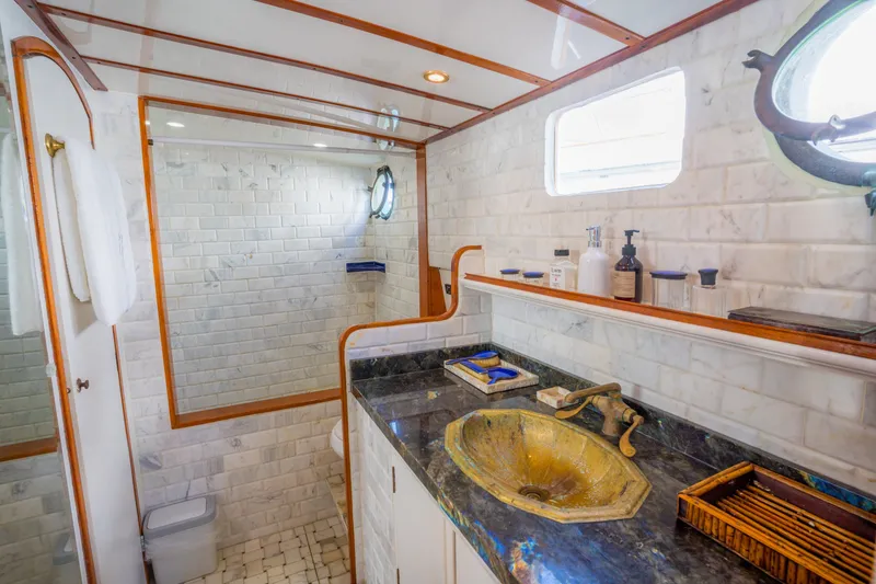 Slide: The Image of Luxurious 1922 Blanchard Shipyard custom yacht bathroom with marble tiles and vintage brass sink. - 57