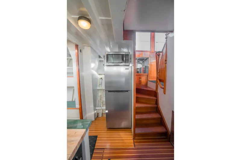 Slide: The Image of Interior of 1922 Blanchard Shipyard Custom boat with modern kitchen appliances and wooden stairs. - 42