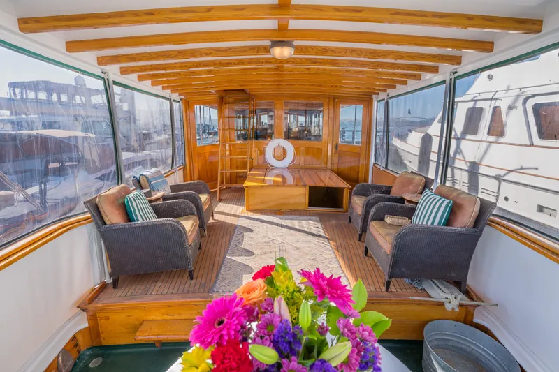 Slide: The Image of Luxurious 1922 Blanchard Shipyard custom boat interior with wicker seating and vibrant flowers. - 7