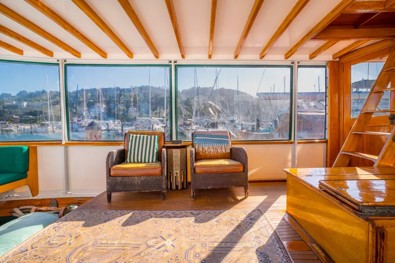 Slide: The Image of Interior of 1922 Blanchard Shipyard custom boat with cozy seating and marina view. - 11