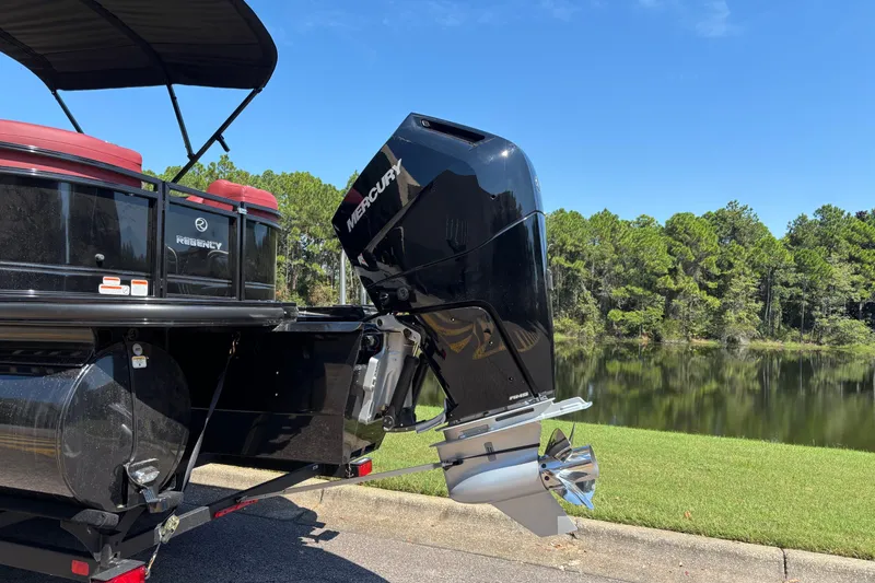Slide: The Image of 2027 Regency R250DL3 boat with Mercury outboard motor by a scenic lake. - 4