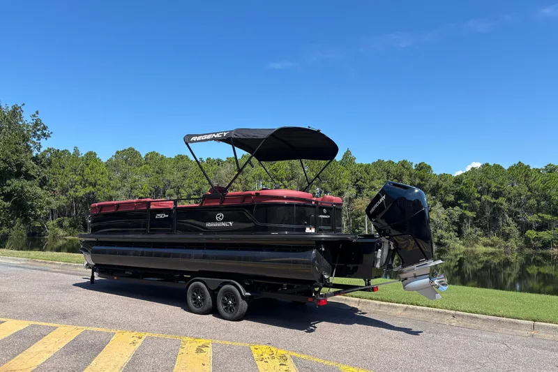 Slide: The Image of 2027 Regency R250DL3 pontoon boat on trailer by a scenic lake. - 3