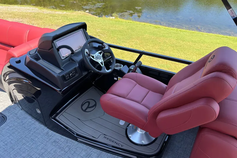 Slide: The Image of Luxurious 2027 Regency R250DL3 boat helm with red seating and modern controls by a lake. - 10