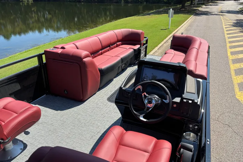 Slide: The Image of Luxurious 2027 Regency R250DL3 pontoon boat with red seating, parked by a serene lake. - 14