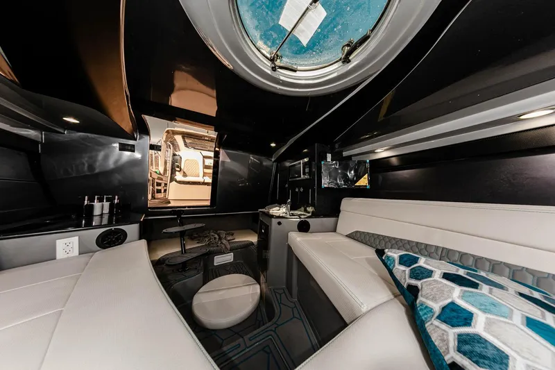 Slide: The Image of Manufacturer Provided Image: Luxurious interior of 2025 Deep Impact 399 Cabin boat with modern seating and porthole view. - 14