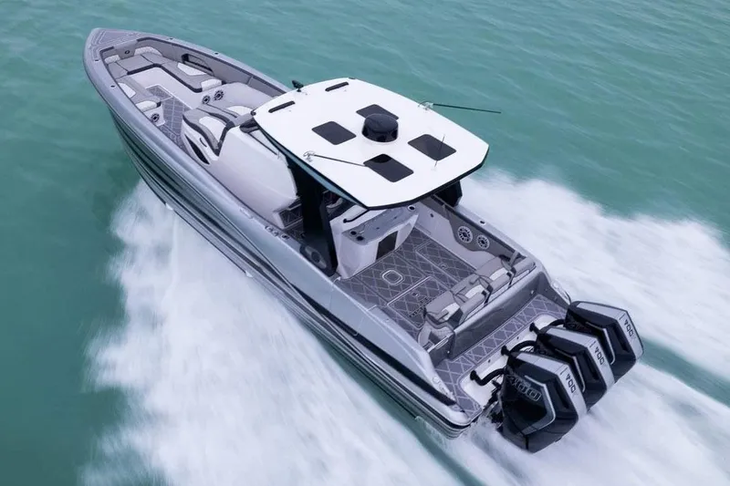 Slide: The Image of Manufacturer Provided Image: 2026 Deep Impact 369 Sport boat cruising on turquoise water, featuring triple outboard engines. - 2