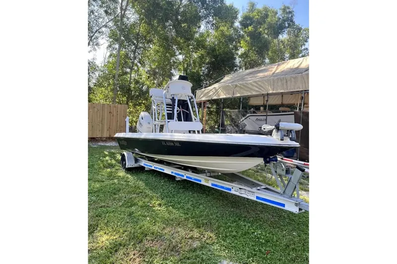 The Image of 2004 ShearWater 2000Z boat on trailer, parked on grass with trees in background. - 0
