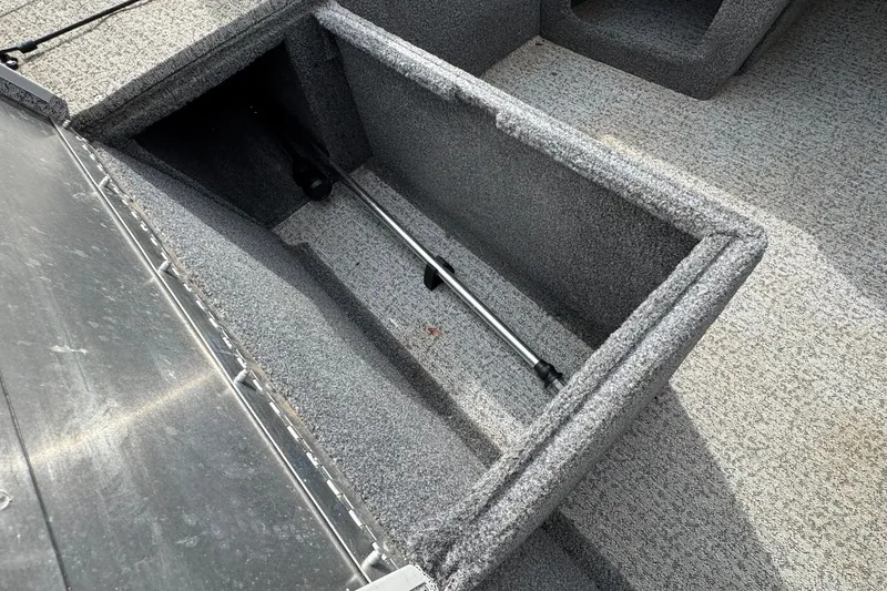 Slide: The Image of 2021 Tracker Pro Team 170 TX boat storage compartment with gray carpet interior. - 13