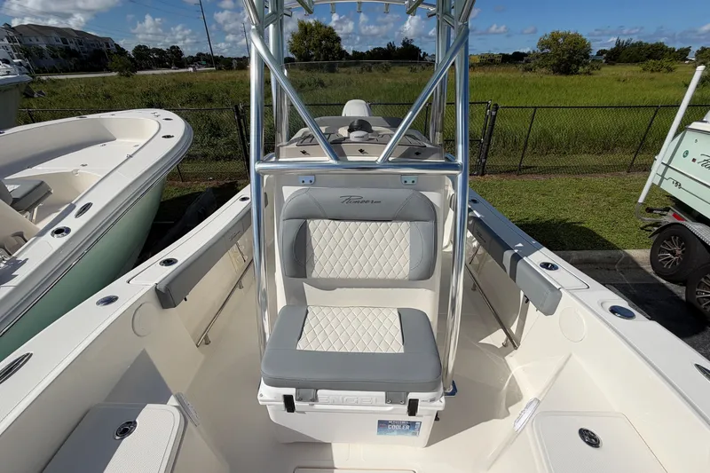 Slide: The Image of 2027 Pioneer 220 Bay Sport boat interior with cushioned seating and storage. - 14