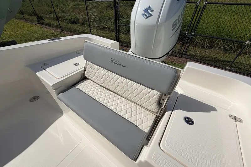 Slide: The Image of 2027 Pioneer 220 Bay Sport boat with cushioned seating and Suzuki outboard motor. - 19