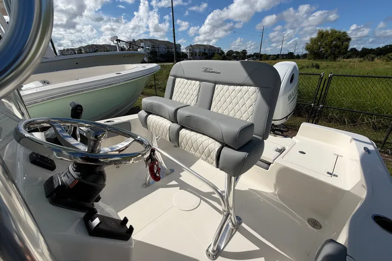 Slide: The Image of 2027 Pioneer 220 Bay Sport boat interior with steering wheel and cushioned seating. - 16