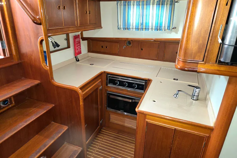 Slide: The Image of 2001 Grand Banks 43 Eastbay HX yacht kitchen with wood cabinetry and modern appliances. - 18