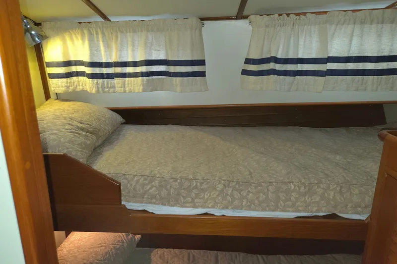 Slide: The Image of Cozy cabin bedroom in 2001 Grand Banks 43 Eastbay HX yacht with wooden accents and curtains. - 23