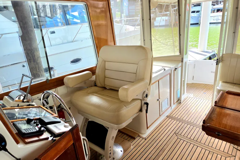 Slide: The Image of Helm station of 2001 Grand Banks 43 Eastbay HX with leather seat and wooden flooring. - 13