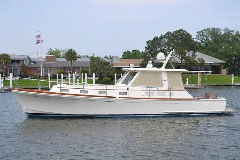 The Image of 2001 Grand Banks 43 Eastbay HX yacht on calm water near a marina. - 1