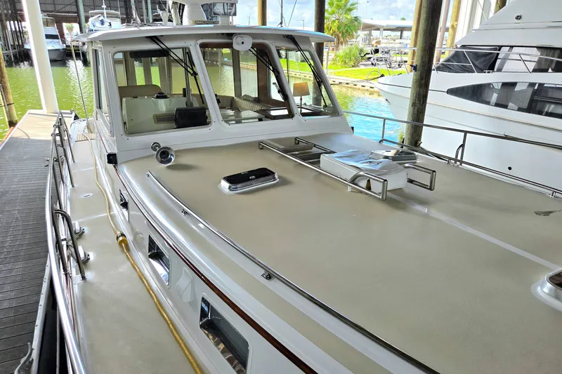 Slide: The Image of 2001 Grand Banks 43 Eastbay HX yacht docked, showcasing sleek design and spacious deck. - 7