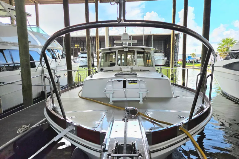 Slide: The Image of 2001 Grand Banks 43 Eastbay HX yacht docked in a marina, surrounded by other boats. - 4