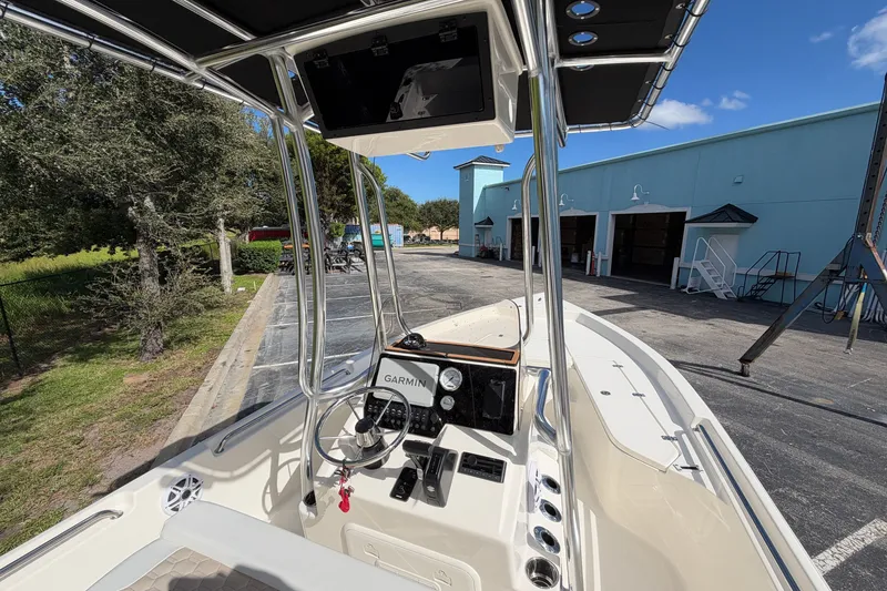 Slide: The Image of 2027 Bulls Bay 2200 XS boat with Garmin navigation, docked near a blue building. - 6