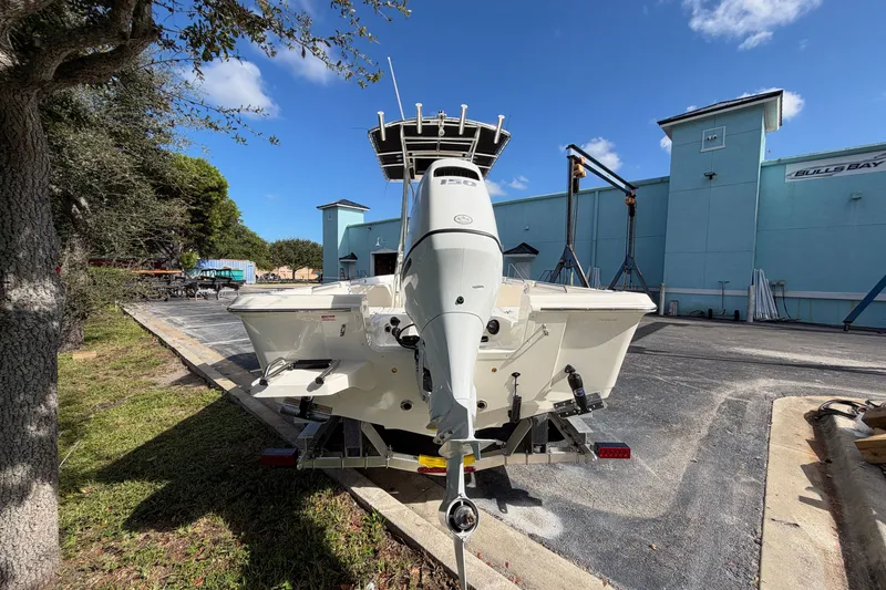 Slide: The Image of 2027 Bulls Bay 2200 XS boat with outboard motor in a marina setting. - 4