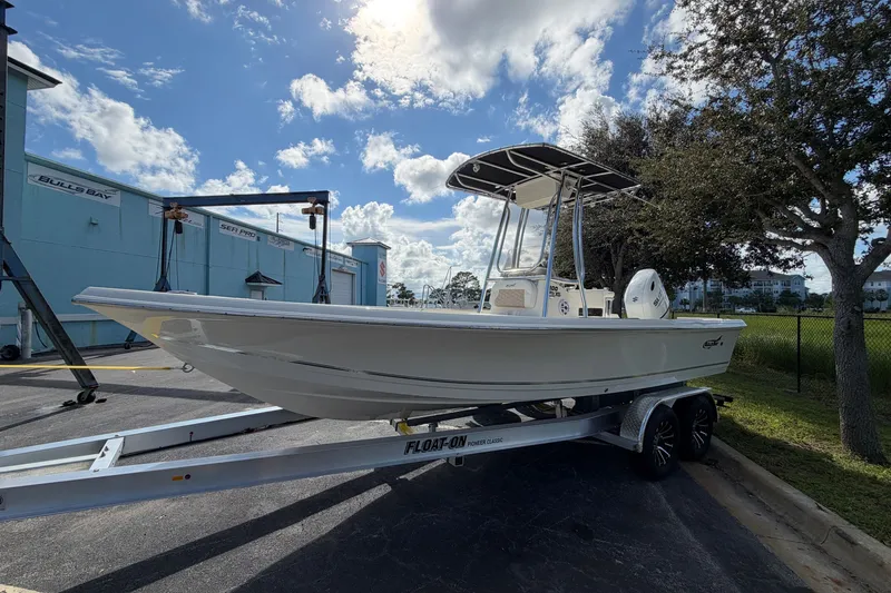 Slide: The Image of 2027 Bulls Bay 2200 XS boat on trailer under sunny sky. - 2