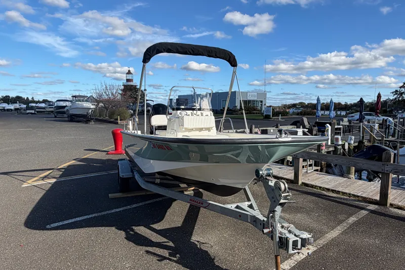 The Image of 2017 Boston Whaler 170 Montauk boat on trailer at marina under blue sky. - 0