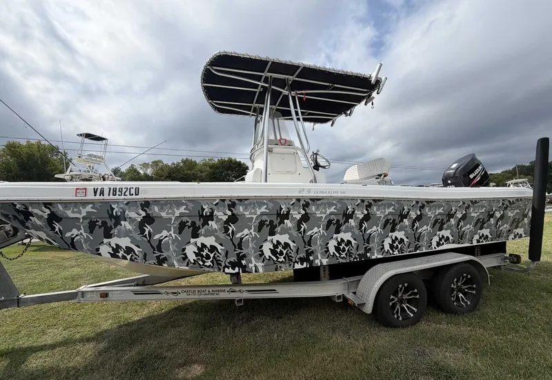 The Image of A 2011 Carolina Skiff 23 Ultra Elite SS with camouflage pattern, parked on a trailer. - 0