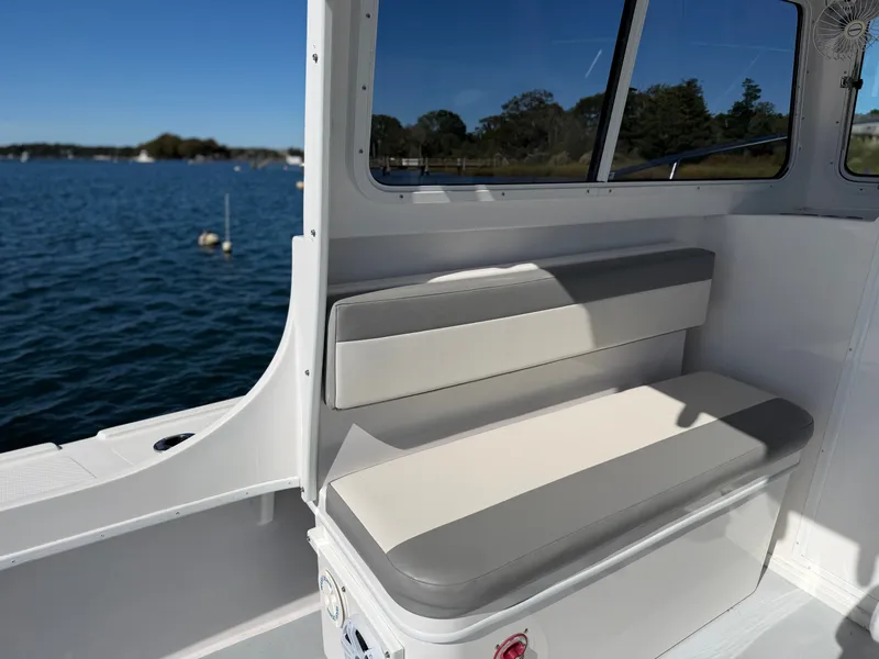 Slide: The Image of The 2024 Steiger Craft 255 Miami features a cushioned bench seat in an open cockpit overlooking the water. - 16