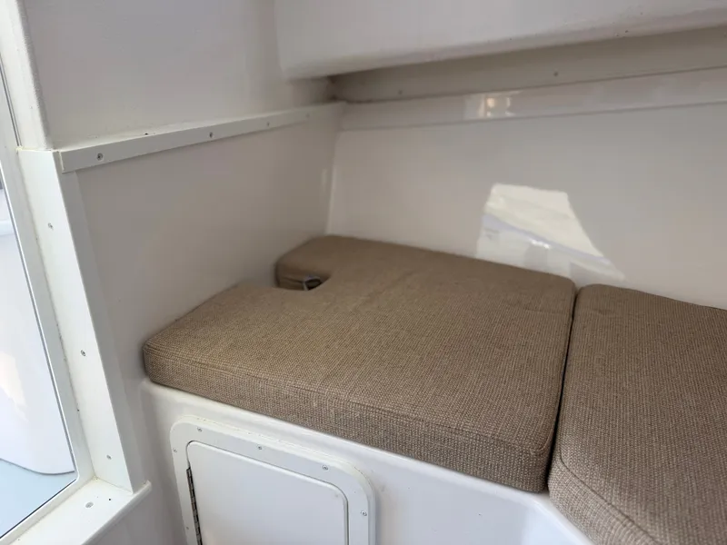 Slide: The Image of The cabin of the 2024 Steiger Craft 255 Miami features cushioned seating in a bright interior. - 19