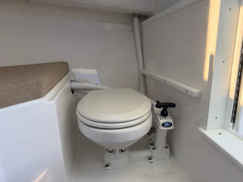 Slide: The Image of The image shows a toilet inside a boat, next to a cushioned bench. - 21